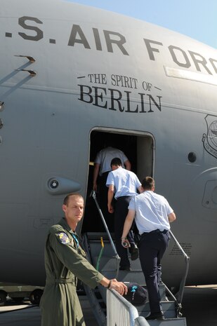 Tech. Sgt. Shane Spradlin, 437th Aircraft Maintenance Squadron flying crew chief from Charleston Air Force Base, S.C., ushers people into the C-17 Globemaster III "Spirit of Berlin" during the ILA 2010 Berlin International Aerospace Exhibition and Conferences June 9 at the Berlin-Schoenefeld Airport. (U.S. Air Force photo/Staff Sgt. Julius Delos Reyes)