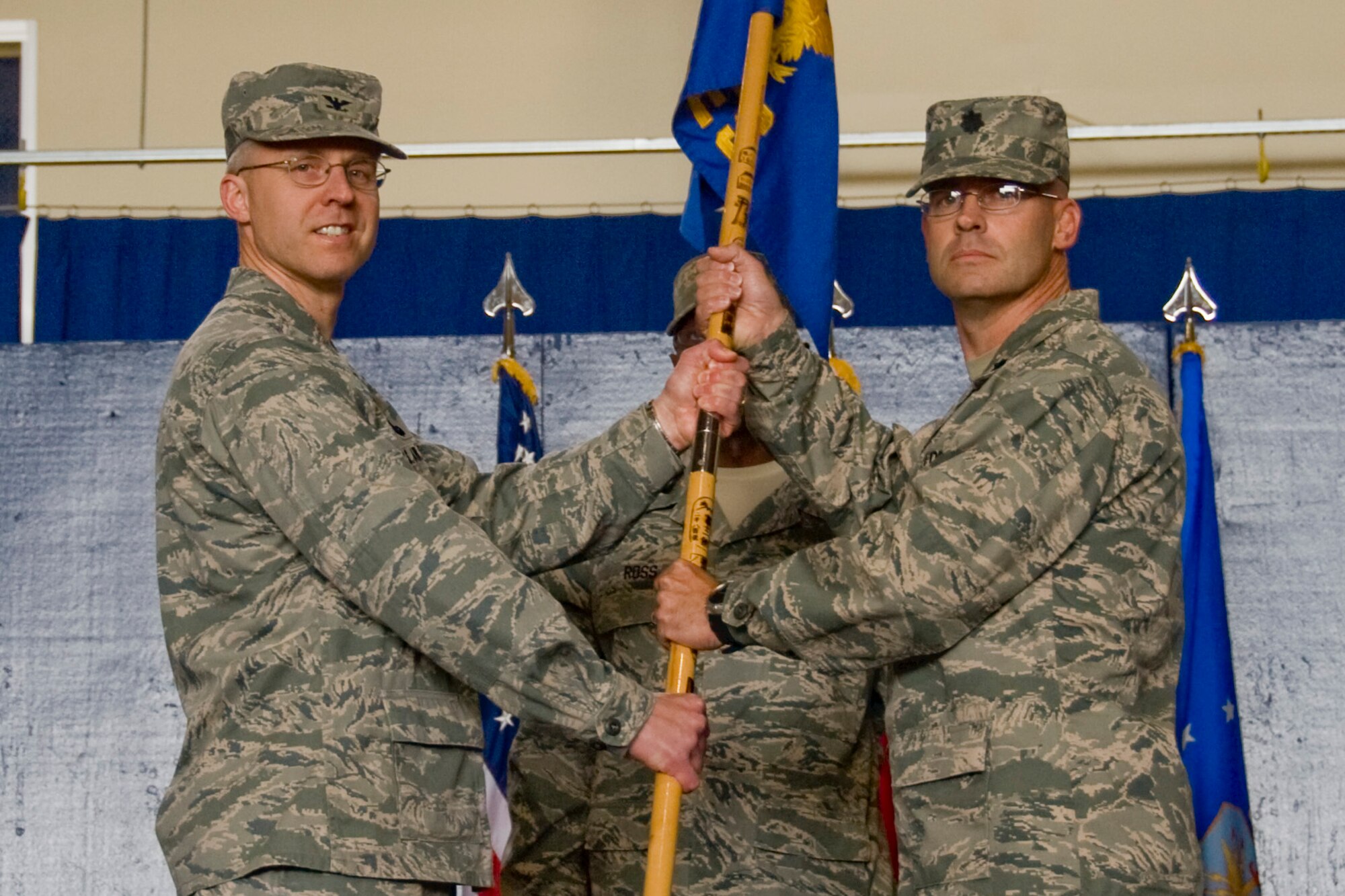 Col. David P. Wiegand, 35th Mission Support Group commander, presents the 35th Civil Engineer Squadron guidon to Lt. Col. Dwayne M. Robison signifying the acceptance of command of the squadron, June 11. The assumption of command ceremony is a military formation deeply rooted in history and tradition dating back to the time of Frederick the Great of Prussia. (U.S. Air Force/ Staff Sergeant Araceli Alarcon)