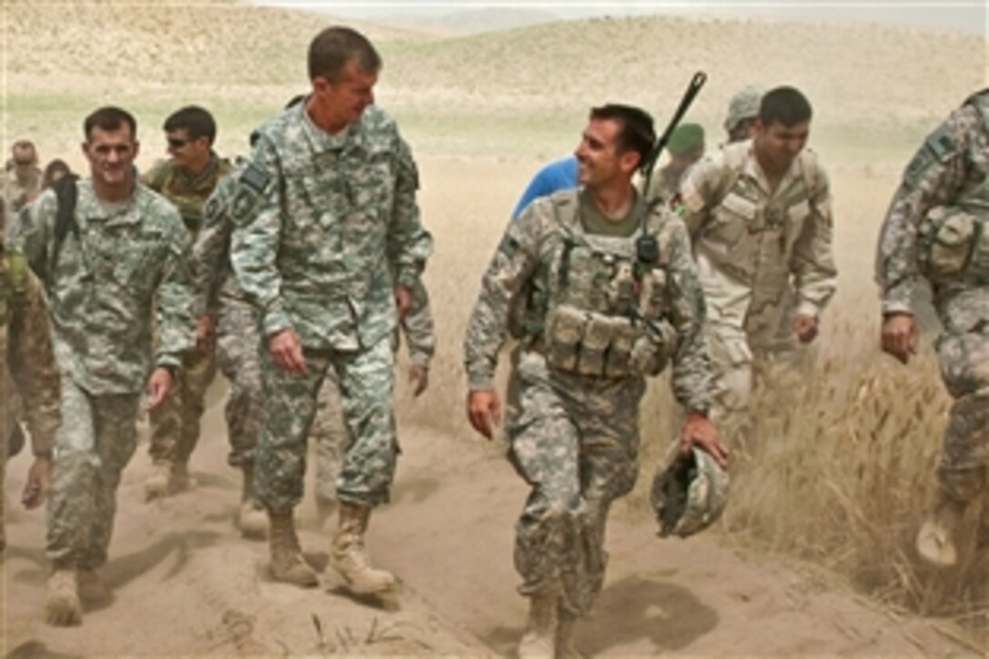 U.S. Army Gen. Stanley A. McChrystal, commander of U.S. and international forces in Afghanistan, speaks with U.S. Army Capt. Joey Nickel during a foot patrol through Muqur district in Afghanistan's Badghis province, June 3, 2010.