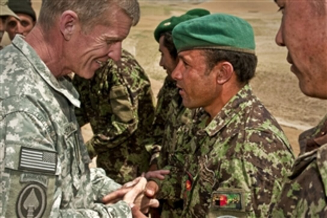 U.S. Army Gen. Stanley A. McChrystal, commander of U.S. and international forces in Afghanistan, greets an Afghan soldier at a combat outpost near the village of Muqur in Afghanistan's Badghis province, June 3, 2010.