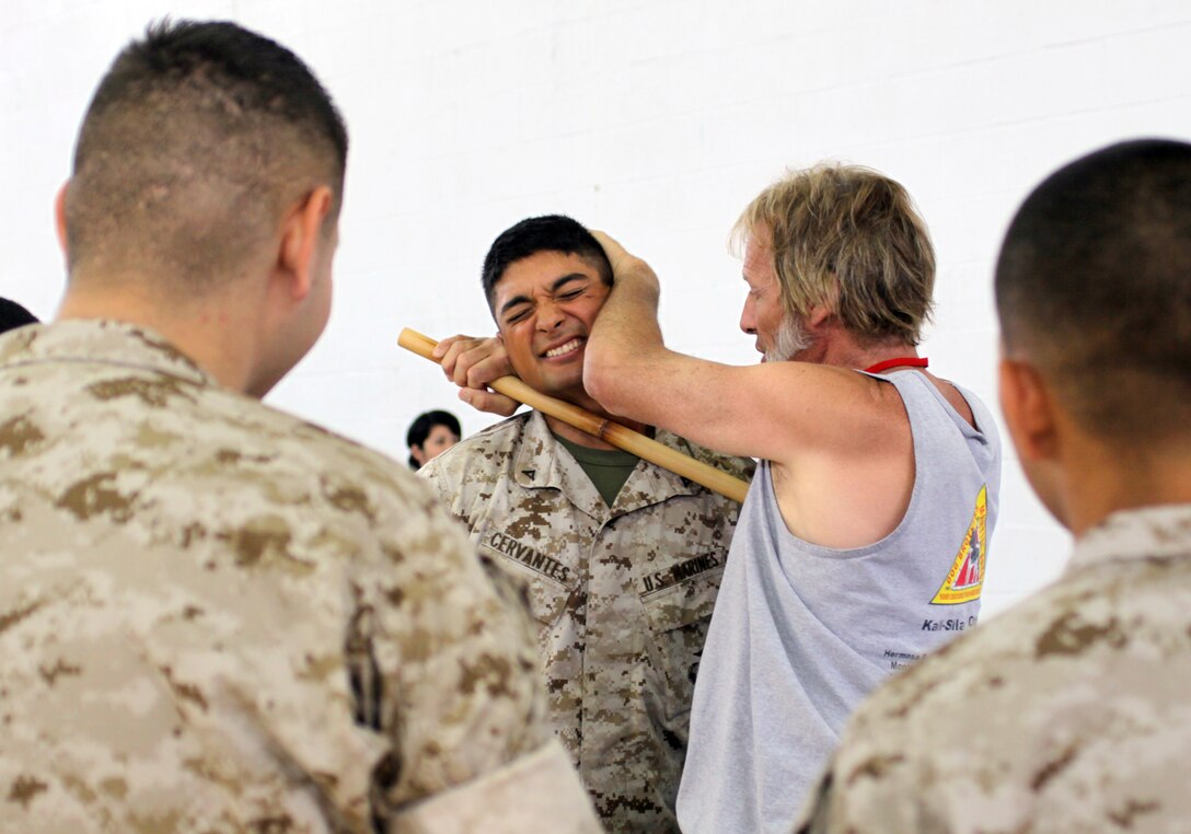 Marc Denny, head instructor and president, Dog Brothers Martial Arts, Hermosa Beach, Calif., right, demonstrates martial art techniques on Lance Cpl. Carlos M. Cervantes, supply clerk, property control office, during the Martial Arts Expo and Men’s Health Fair.