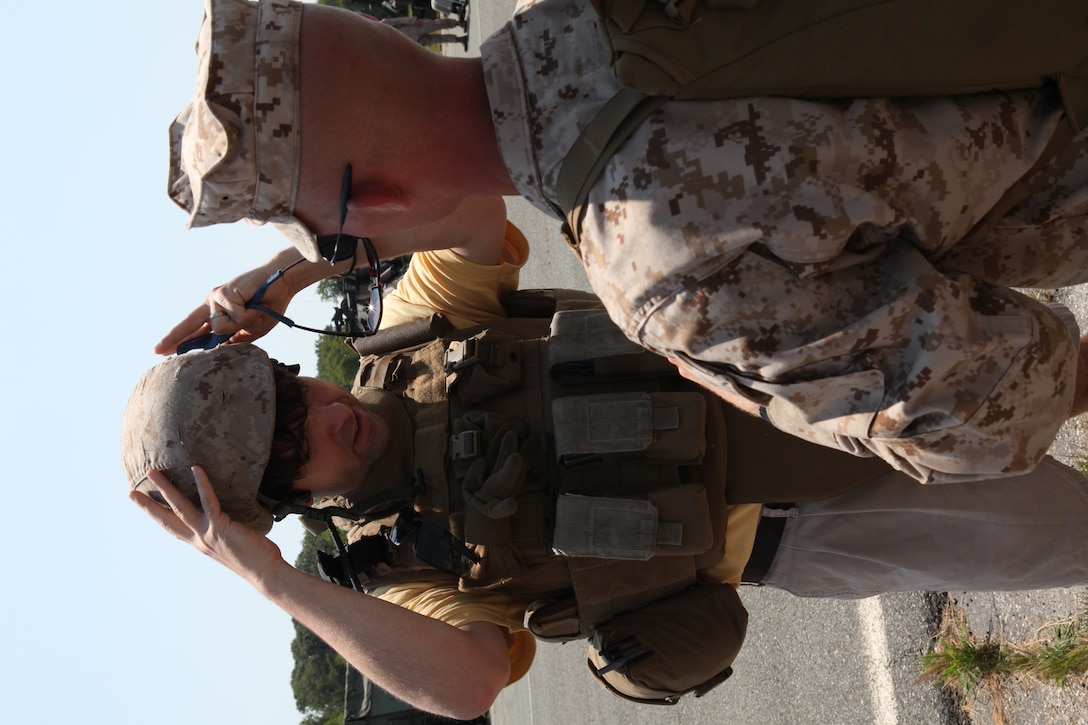 Larry Foulk, a local resident of Tappahannock, Va., tries on a helmet and modular tactical vest during a community outreach day held by 26th Marine Expeditionary Unit at Tappahannock Municipal Airfield, June 12, 2010. 26th MEU held a community outreach day to thank the local community for their patriotic support and hospitality during Realistic Urban Training at nearby Fort A.P. Hill, Va.