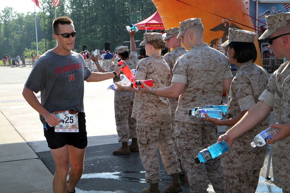 Runner Steven Meints accepts powerade from Marines with Headquarters & Service Battalion, Marine Corps Base Quantico, Va., after crossing the finish line of the Marine Corps Marathon Crossraods 17.75K June 12, 2010. The Marine Corps offered hospitality in the form of sports drinks, water and snacks to replenish the runners after the 11 mile ordeal.
