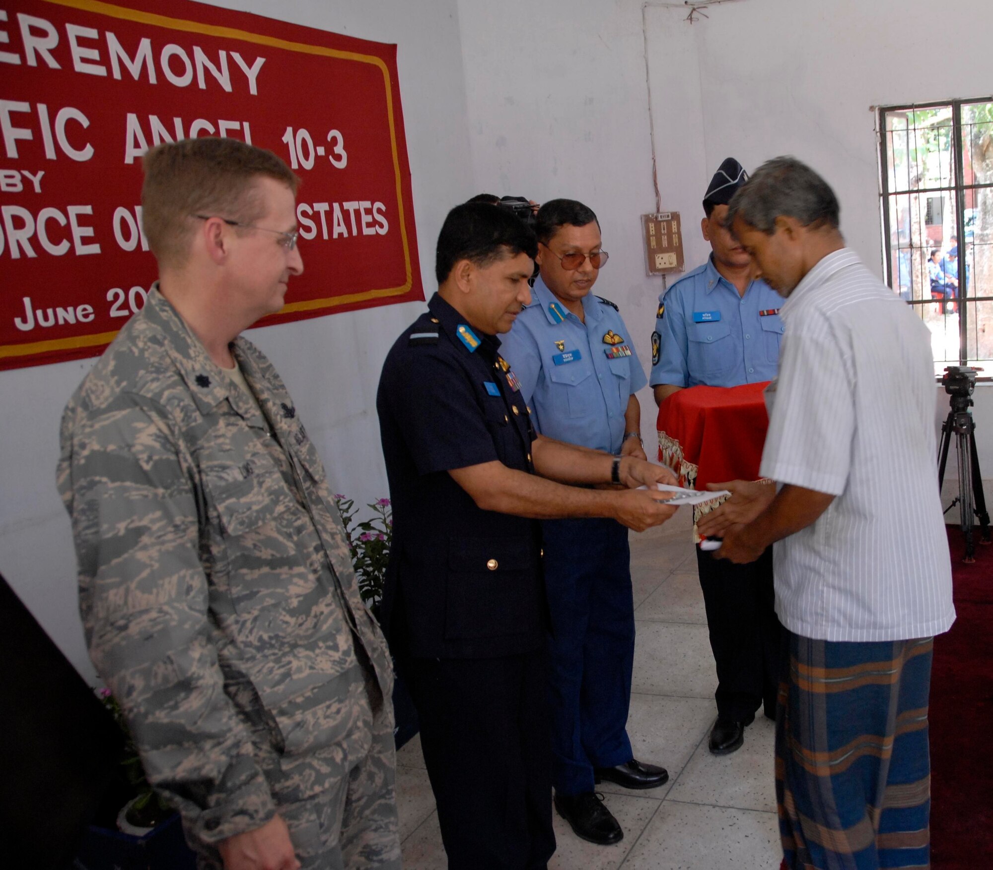 Air Commodore M. Abul Bashar (right), from the Bangladesh Air Force, provides medicine to a local citizen during the opening ceremonies of Operation Pacific Angel in Jessore, Bangladesh, on June 12, 2010. Operation Pacific Angel is a joint and combined humanitarian assistance operation conducted in the Pacific area of responsibility to support U.S. Pacific Command's capacity-building efforts. This humanitarian and civic assistance program is aimed at improving military civic cooperation between the United States and countries throughout the Asia-Pacific region. More than 55 U.S. military personnel are participating in civil and medical assistance programs with the help of the Bangladesh Air Force and local nongovernmental organizations. Medical care for Bangladesh citizens will include: primary care, women's health, dental and optometry. The operation is scheduled through June 16, 2010. (U.S. Air Force photo/1st Lt. Chris Hoyler)