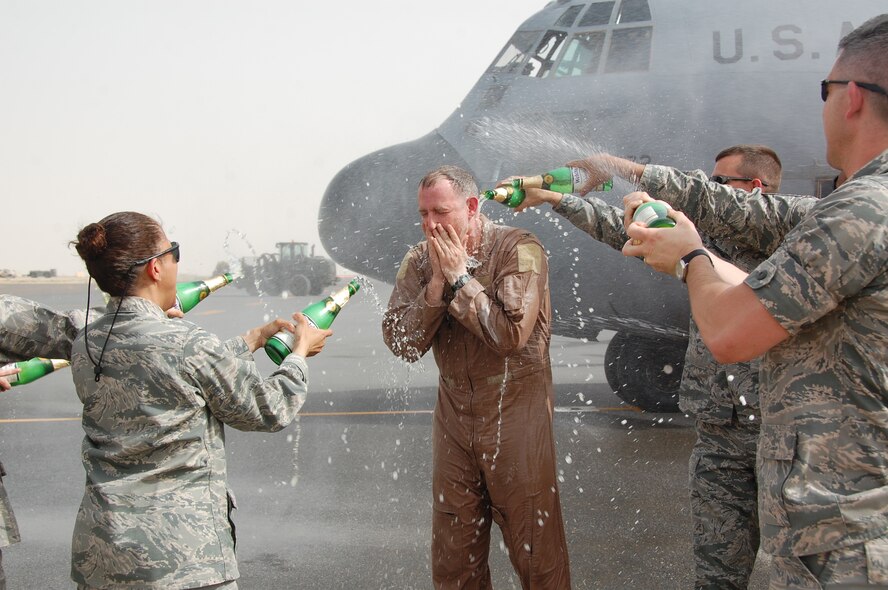 U.S. Air Force members of the 386th Air Expeditionary Wing douse Col. John R. Gordy II, 386th AEW commander, with non-alcoholic sparking champagne after he completed his last flying mission here June 12, 2010 at an undisclosed location in Southwest Asia. Colonel Gordy will relinquish command of the 386th AEW in a ceremony later this month and then head to his next assignment at the Pentagon.  Colonel Gordy is a master navigator with more than 4,700 flight hours in C-130 E/H and T-43 aircraft.  (U.S. Air Force photo/Staff Sgt. Lakisha A. Croley)
