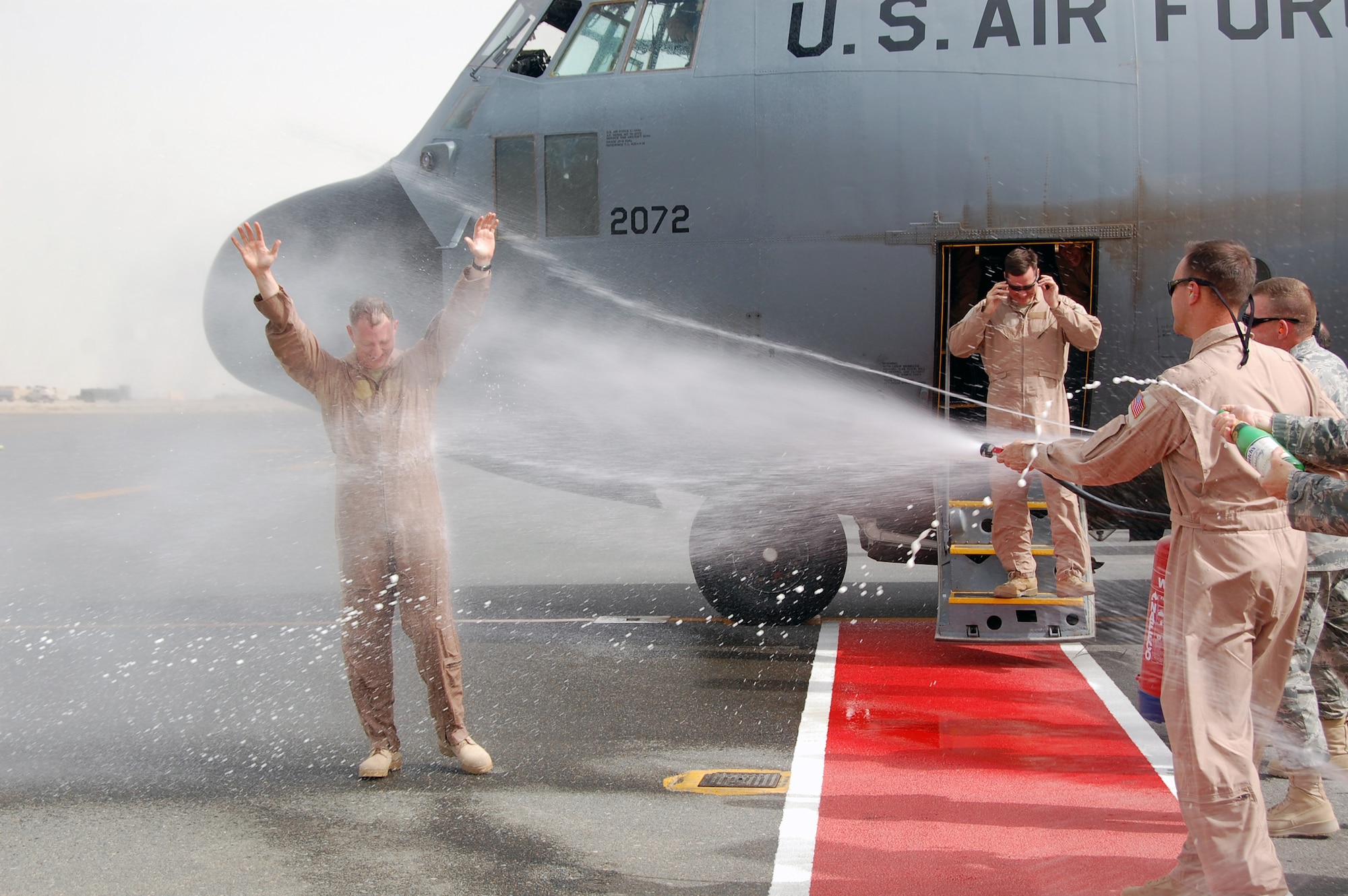 Air Force Col. John R. Gordy II, 386th Air Expeditionary Wing commander gets the traditional dousing of water from a fire hose and extinguisher as well as non-alcoholic sparkling champagne after completing his last flying mission here June 12, 2010.  Colonel Gordy will relinquish command of the 386th AEW in a ceremony later this month and then head to his next assignment at the Pentagon.  Colonel Gordy is a master navigator with more than 4,700 flight hours in C-130 E/H and T-43 aircraft.  (U.S. Air Force photo/Staff Sgt. Lakisha A. Croley)