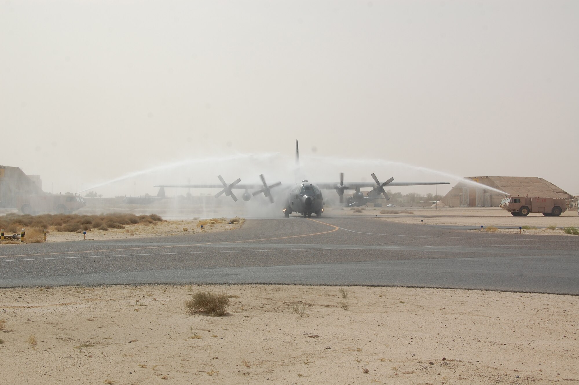A C-130H aircraft enters an arch of water sprayed from fire trucks here June 12, 2010 as part of a ?fini flight? salute to Air Force Col. John R. Gordy II, 386th Air Expeditionary Wing commander returning from his last flying mission.  Colonel Gordy will relinquish command of the 386th AEW in a ceremony later this month and then head to his next assignment at the Pentagon.  Colonel Gordy is a master navigator with more than 4,700 flight hours in C-130 E/H and T-43 aircraft. (U.S. Air Force photo/Staff Sgt. Lakisha A. Croley)