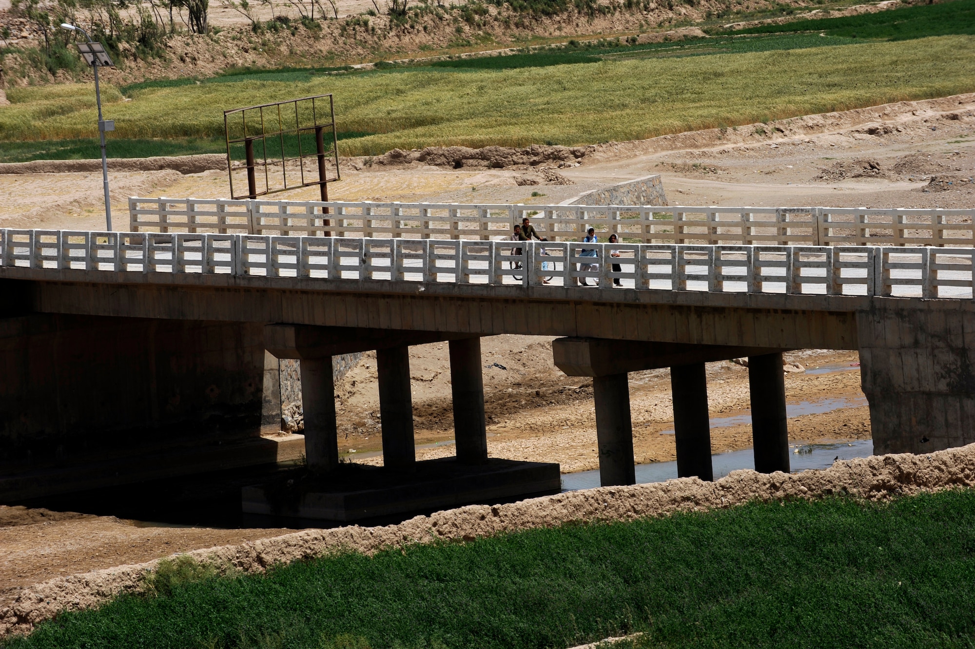 Afghans cross the Tarnak Bridge, currently being repaired by Provincial Reconstruction Team Zabul and Zabul Province government officials May 27, 2010, Qalat City, Afghanistan. (U.S. Air Force photo/Staff Sgt. Manuel J. Martinez/released) 
