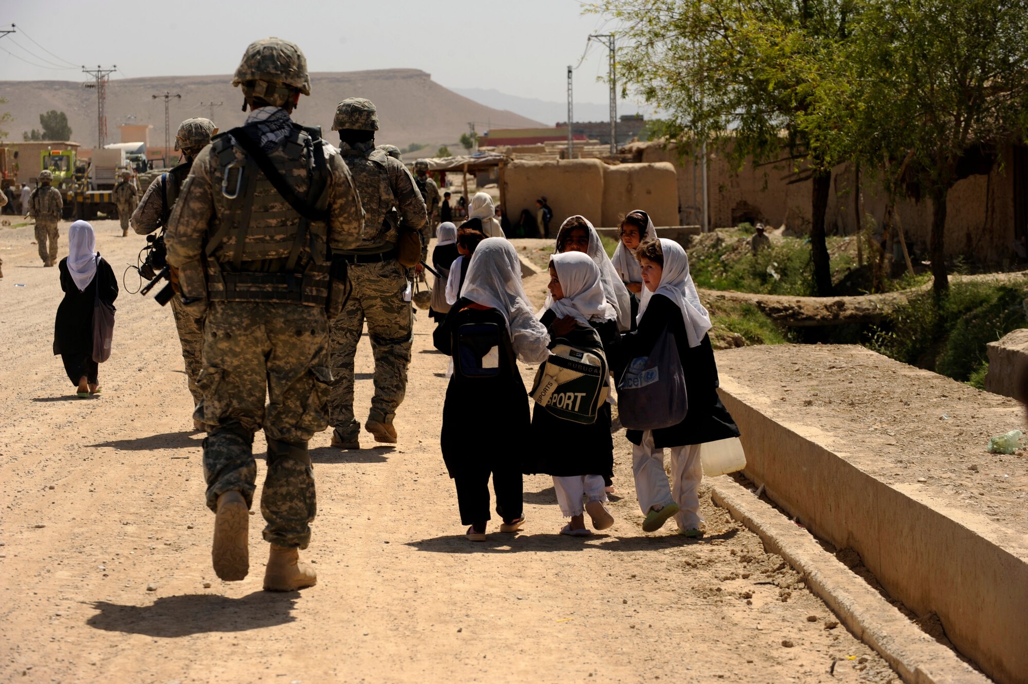 Afghan students from the Bibi Khala Girl's School walk home after a day of school alongside U.S. Soldiers and Airmen assigned to Provincial Reconstruction Team Zabul May 31, 2010, in Qalat City, Afghanistan. ?The last two PRTs that have come to assist the school here have helped us tremendously,? said Mehmooda, Bibi Khala Girl?s School head mistress. ?The PRT has shown great support for the school and its students. Our young ladies feel more secure and have less fear since the PRT has been involved with us. Also, our girls enjoy all the improvements, because they feel like somebody cares about them.? (U.S. Air Force photo/Staff Sgt. Manuel J. Martinez/released) 


