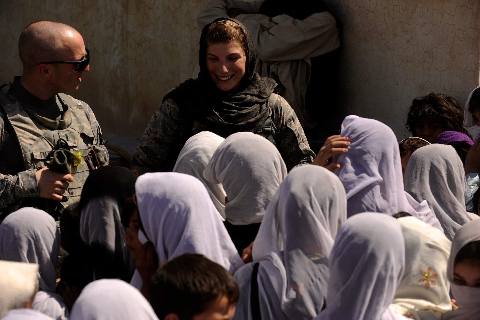 First Lt. Shane Futchko, a physician assistant assigned to Provincial Reconstruction Team Zabul, listens as 1st Lt. Rebecca Heyse, information officer assigned to PRT Zabul, sings the ?ABC? song with students at the Bibi Khala Girl's School May 31, 2010, in Qalat City, Afghanistan. ?It was a thrill to sing the ?ABC? song with some of the students here,? Lieutenant Heyse said. ?I have learned a few Pashtu phrases as well, but they speak English way better than I speak Pashtu. For me though, seeing them enjoying their school environment makes me feel like the improvements we are helping them make to the school, is a real investment in these children?s future.? (U.S. Air Force photo/Staff Sgt. Manuel J. Martinez/released) 

