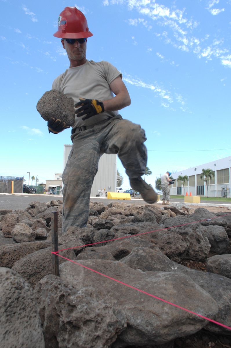 Staff Sgt. Cris Casteel carefully picks out lava rocks being used for a planter in front of the multi-purpose building at USCG Air Station Barbers Point, Hawaii, June 10, 2010. The Civil Engineering Squadron was assigned the task of remodeling the multi-purpose building used by Coast Guard Personnel on site. (DoD photo by Airman 1st Class Nicholas Carzis, U.S. Air Force) 