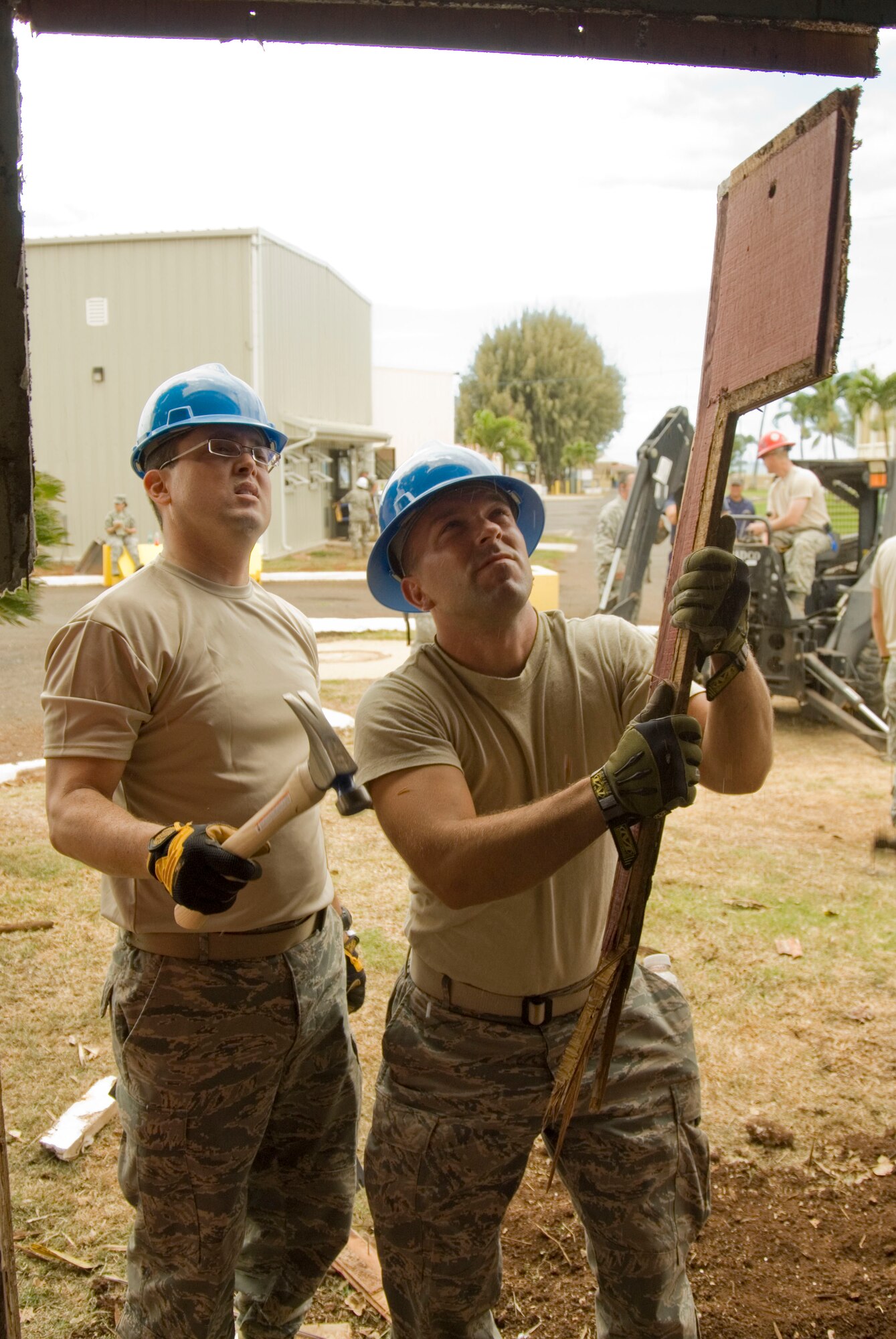 Airman 1st Class Jose Barquero and Airman 1st Class George Kozumplik tear down the remainder of what used to be a wall at the multi-purpose building at USCG Air Station Barbers Point, Hawaii, June 10, 2010. The Civil Engineering Squadron was assigned the task of remodeling the multi-purpose building used by Coast Guard personnel on site. (DoD photo by Airman 1st Class Nicholas Carzis, U.S. Air Force)