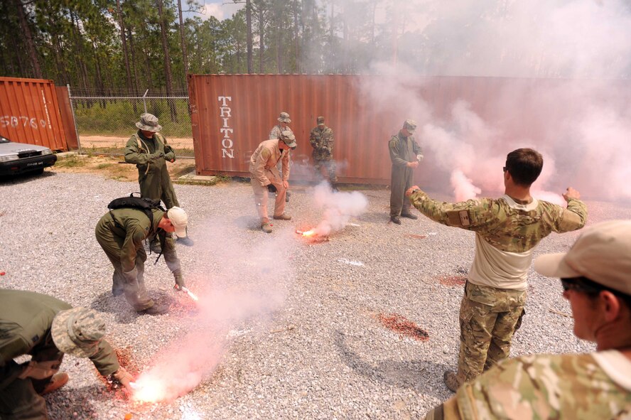 Survival, Evasion, Resistance and Escape specialists look on as Airmen properly use their smoke flares during combat skills training at an undisclosed location within the Eglin Range, Fla., May 13, 2010.  SERE specialists are able to utilize the multitude of resources and experiences from their fellow 1st Special Operations Support Squadron Range Support flight to prepare Airmen for situations that may happen in combat. (DoD photo by U.S. Air Force Senior Airman Matthew Loken/Released)