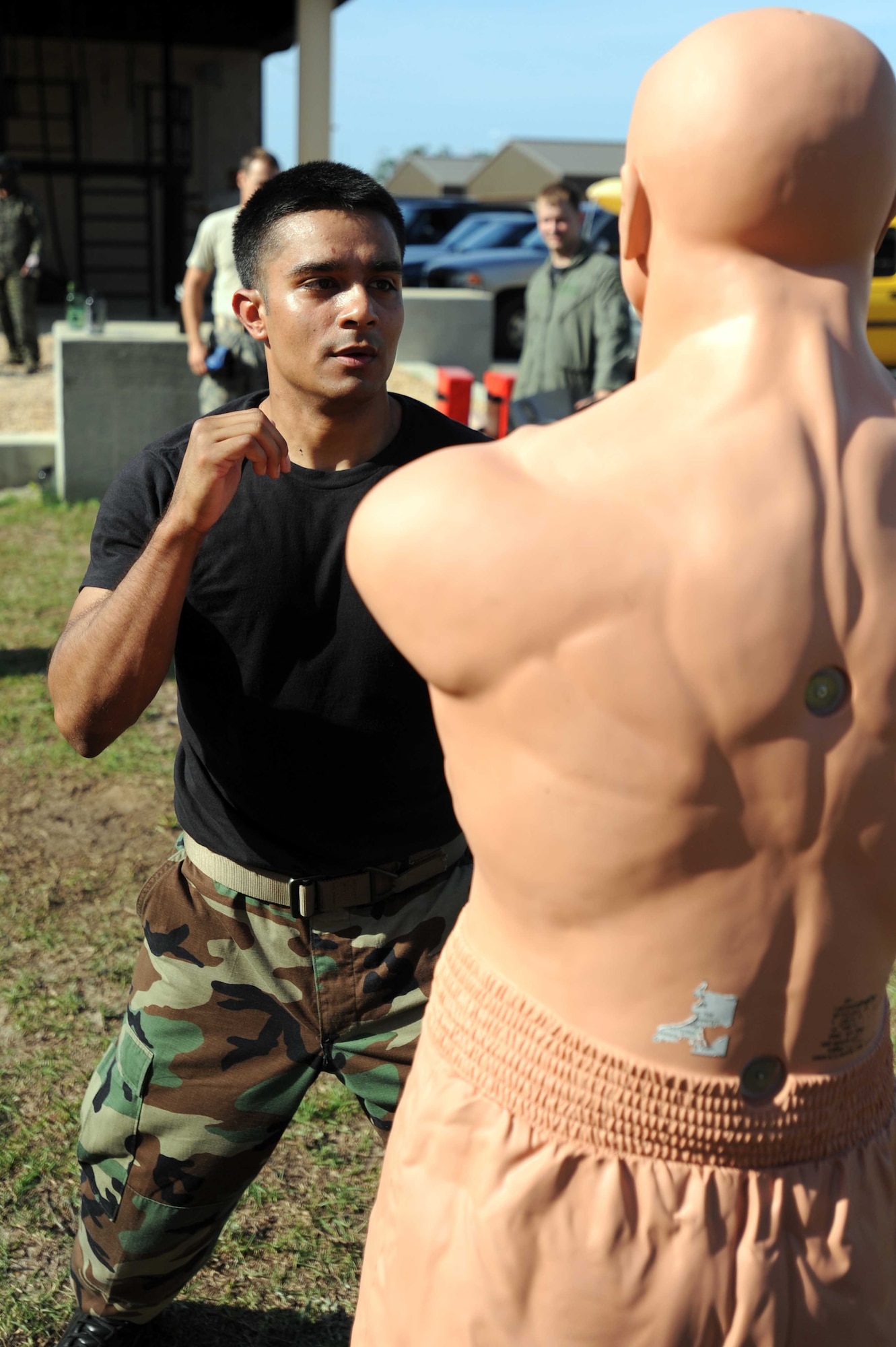 A Hurlburt Airman participating in Survival, Evasion, Resistance, and Escape training, prepares to hit a strike-dummy during combat skills training outside the SERE training center at Hurlburt Field, Fla., May 13, 2010.  SERE specialists are able to utilize the multitude of resources and experiences from their fellow 1st Special Operations Support Squadron Range Support flight to prepare Airmen for situations that may happen in combat. (DoD photo by U.S. Air Force Senior Airman Matthew Loken/Released)