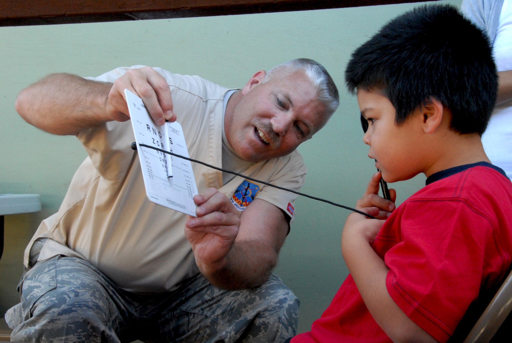 Staff Sgt. Bill McConaha performs an eye screening to test near vision on a patient June 8, 2010, in Kona, Hawaii. Airmen from the 178th MDG are on a medical training deployment to provide free medical services to underprivileged communities that do not have access to health care on the island. Sergeant McConaha is an optometry technician with the 178th Medical Group. (U.S. Air Force photo/Senior Airman Amy Adducchio)