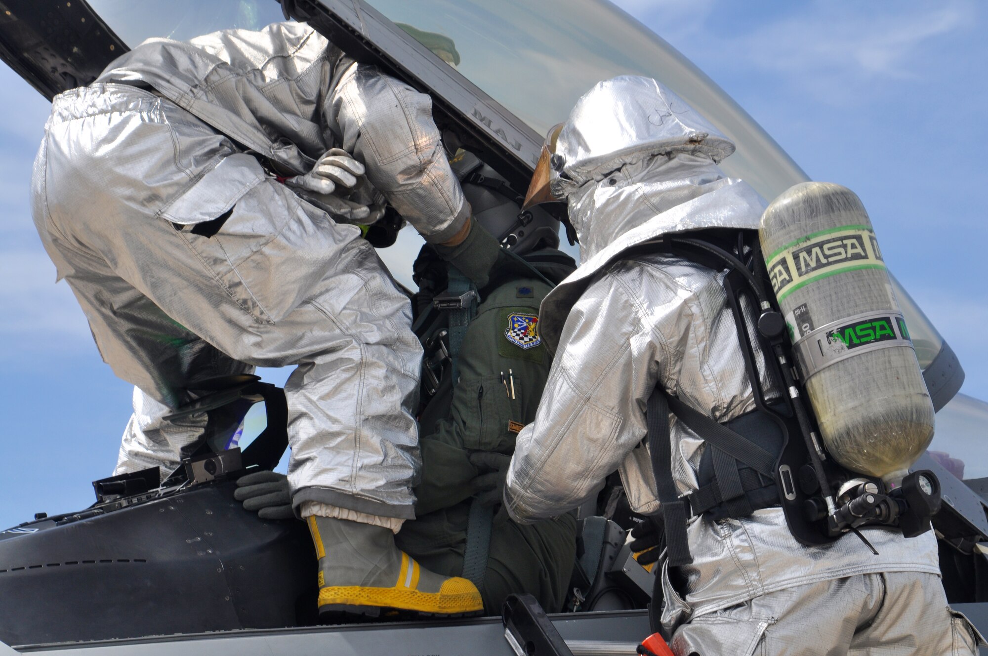 Firefighters Staff Sgt. Jeffery Griffen and Staff Sgt. Chad Carrier, 419th Civil Engineer Squadron, lift Lt. Col. Eric Roman, 419th Wing Plans, from the pilot’s seat to extract him from the aircraft. (U.S. Air Force photo/Staff Sgt. Kyle Brasier)