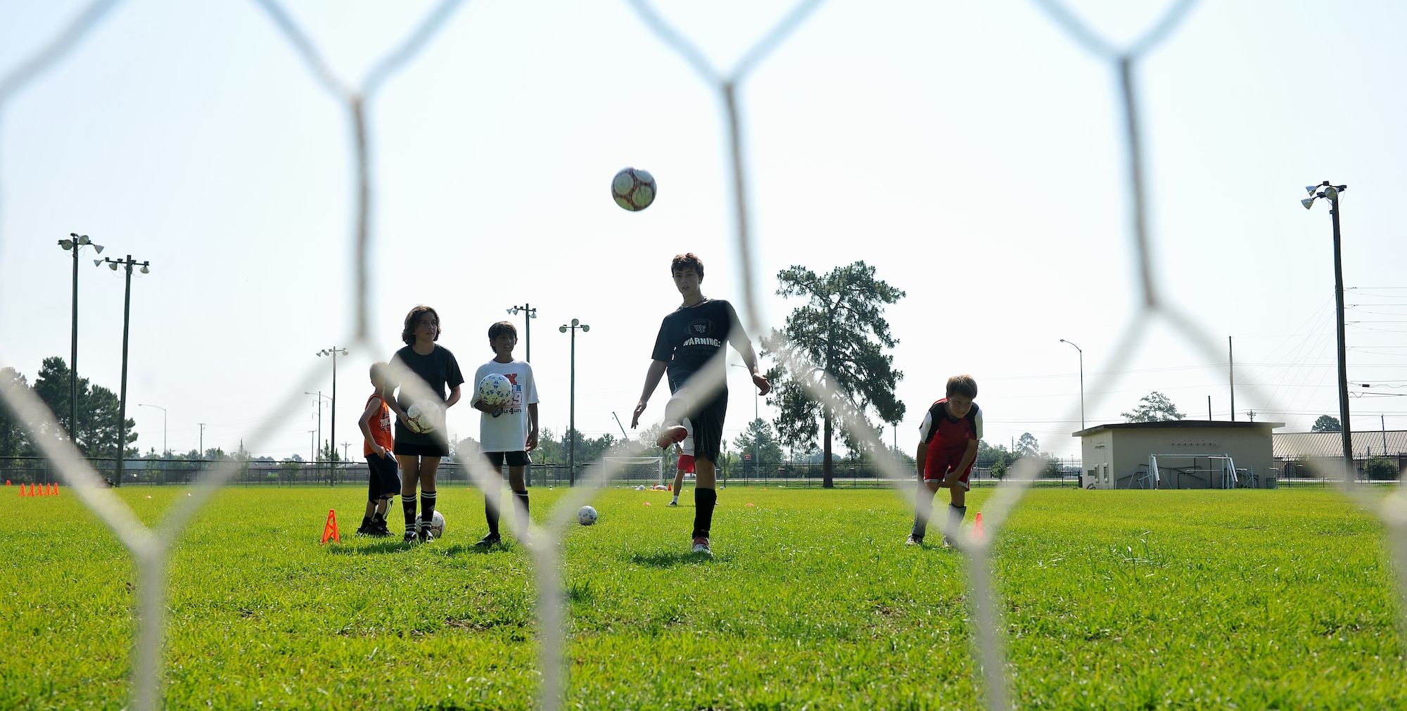 MOODY AIR FORCE BASE, Ga. -- Children perform drills that challenge them to kick the ball on top of the net during a Major League Soccer camp here June 11. Most of the drills were done consecutively and became more challenging as the day went on. (U.S. Air Force photo by Airman 1st Class Joshua Green/RELEASED)