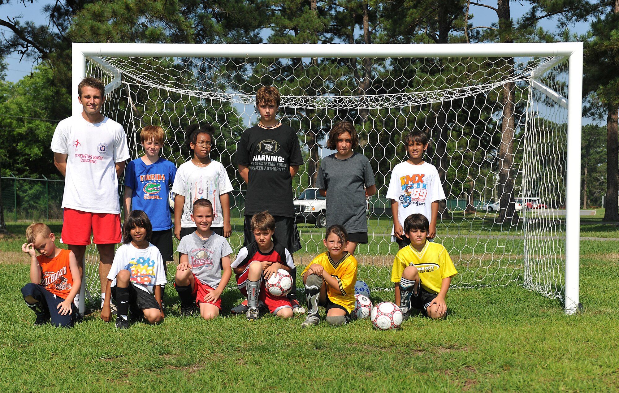 MOODY AIR FORCE BASE, Ga. -- Youth Center children gather around the goal for a group photo during a Major League Soccer camp here June 11. The camp is held for children age two to 12 years old and is held annually. (U.S. Air Force photo by Airman 1st Class Joshua Green/RELEASED)