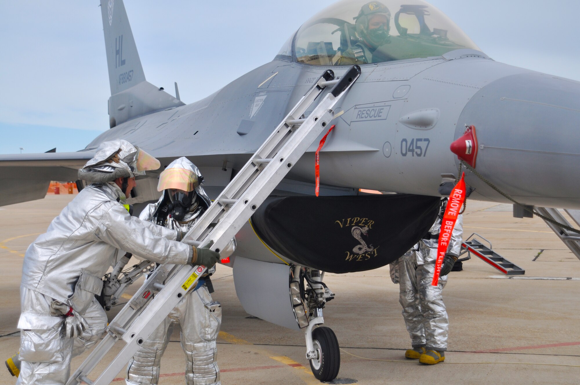 Firefighters Staff Sgt. Jonathan Jimenez and Staff Sgt. Jeffery Griffen, 419th Civil Engineer Squadron, place a ladder against the F-16 to gain access to the trapped pilot. (U.S. Air Force photo/Staff Sgt. Kyle Brasier)
