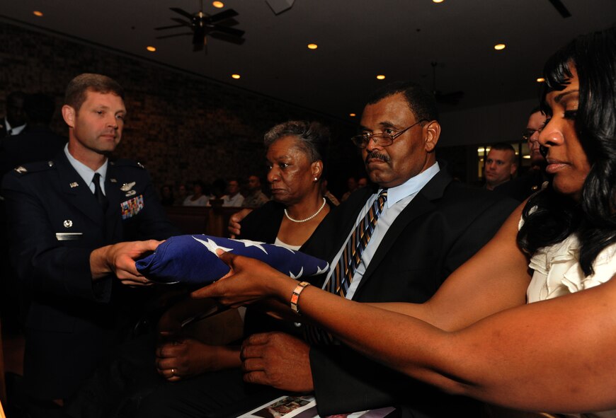 MOODY AIR FORCE BASE, Ga. -- Col. Gary Henderson, 23rd Wing commander, gives a flag to the family of Staff Sgt. Stephanie Farmer during Sergeant Farmer’s memorial service here June 11. Sergeant Farmer leaves behind her parents, siblings and her 1-year old son named Landyn Green. (U.S. Air Force photo by Airman 1st Class Benjamin Wiseman/RELEASED)