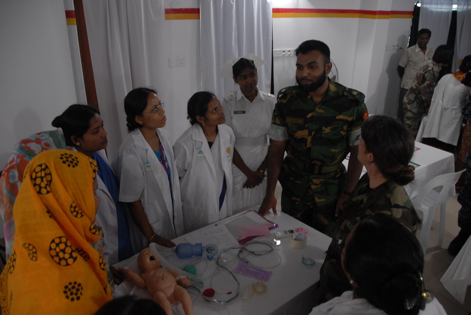 Maj. Mofazzol Hossain, left, Bangladesh Army pediatrician, and Lt. Col. Lindy Winter, Chief of Neonatology at the U.S. Naval Hospital on Camp Lester in Okinawa, Japan, discuss neonatal care with Bangladeshi health care providers during a subject matter expert exchange at the Smiling Sun Clinic in Jessore, Bangladesh June 12. Operation Pacific Angel is a joint and combined humanitarian assistance operation conducted in the Pacific area of responsibility to support U.S. Pacific Command's capacity-building efforts. This humanitarian and civic assistance program is aimed at improving military civic cooperation between the United States and countries throughout the Asia-Pacific region. The exchange was part of Pacific Angel 10-3, which will be held in Bangladesh through June 16. (U.S. Air Force photo by 1st Lt. Chris Hoyler) 