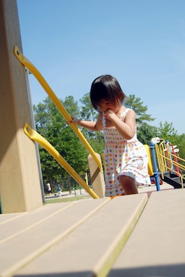 Novella McDonough, 3, uses the handrails of a slide at Pope’s Child Development Center, June 11. To promote safety and prevent accidents, while on the playground, parents should actively supervise children. (U.S. Air Force photo/ 1st Lt. Cammie Quinn) 