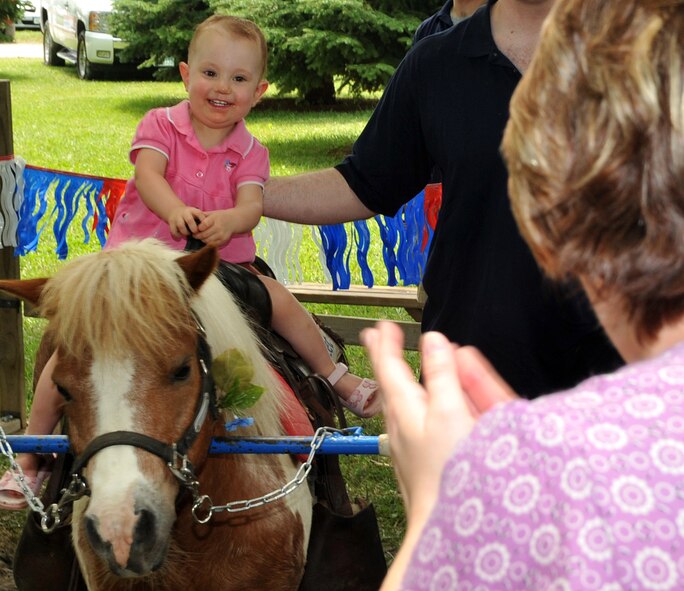 OFFUTT AIR FORCE BASE, Neb. - Twenty-month-old month Lily Dunlow, daughter of Offutt employees Neil and Mellissa Dunlow, enjoys a pony ride during the Offutt Advisory Council's Annual Offutt Appreciation Picnic June 11 at the base lake. During the event, Team Offutt employees and their families enjoyed a day in the sun that included free food, beverages and enterainment. U.S. Air Force photo by Jeff W. Gates 