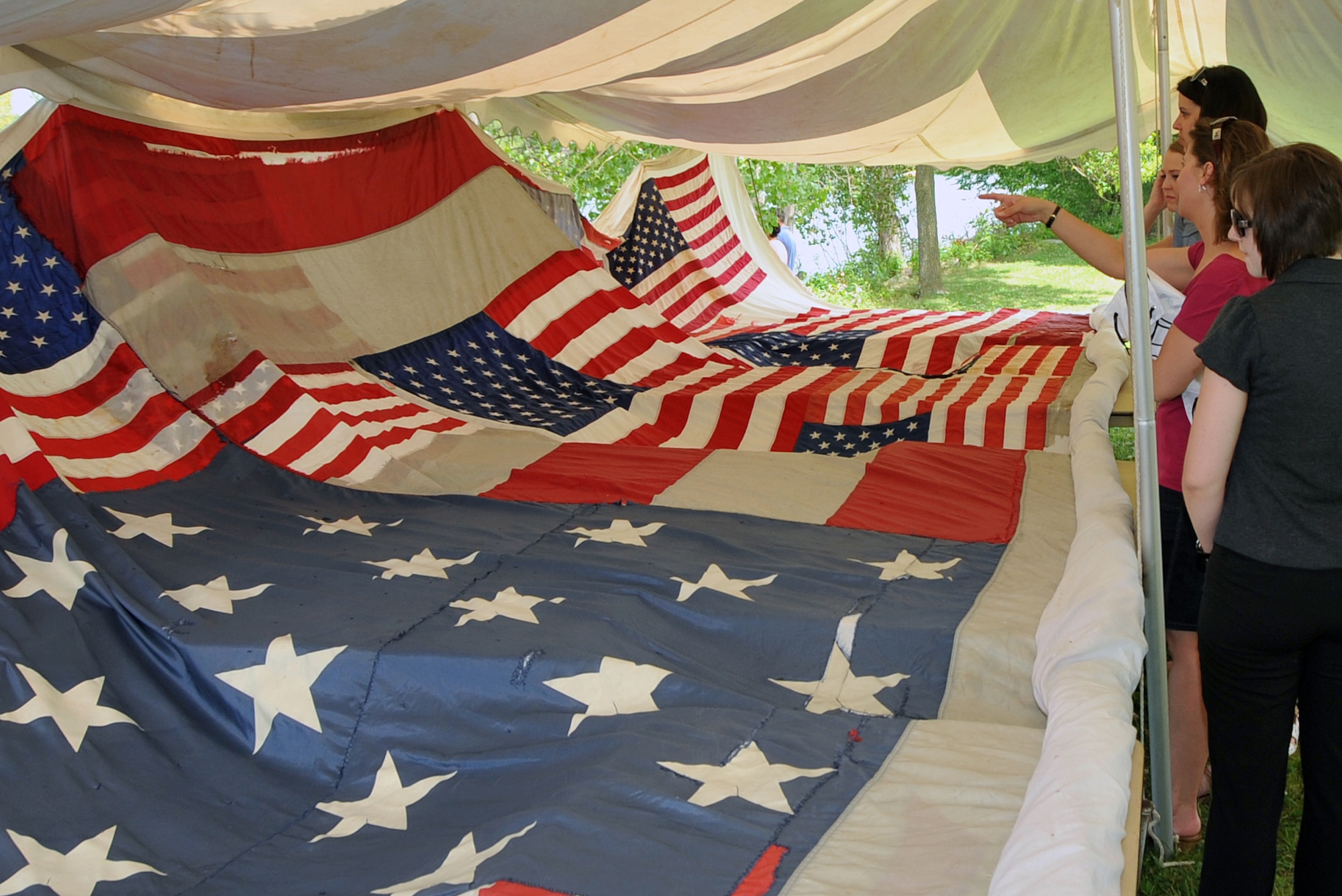 OFFUTT AIR FORCE BASE, Neb. - The National 9/11 Flag was on exhibit at the Offutt Appreciation Picnic this year. The flag was constructed by the New York Says Thank You Foundation, stitched together by residents of Greensburg, Kansas after the town was destroyed by a tornado. Team Offutt Members enjoy a day in the sun with complimentary hot dogs, hamburgers and entertainment at the Offutt Advisory Councils Annual Appreciation Picnic at the base lake here. Activities including live musical entertainment, games, zoo exhibits, inflatables and prizes were provided by local businesses for local residents of the community. U.S. Air Force photo by Jeff W. Gates 