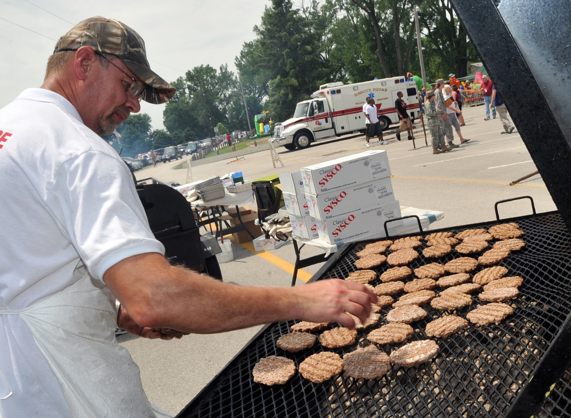 OFFUTT AIR FORCE BASE, Neb. - Volunteer Doug Johnson, a member of GT Midwest in Omaha, throws some more burgers on the grill during the Offutt Advisory Council's Annual Appreciation Picnic June 11 at the base lake. Team Offutt members enjoyed a day filled with free food, beverages and entertainment courtesy of the comunity support organization. U.S. Air Force photo by Jeff W. Gates 