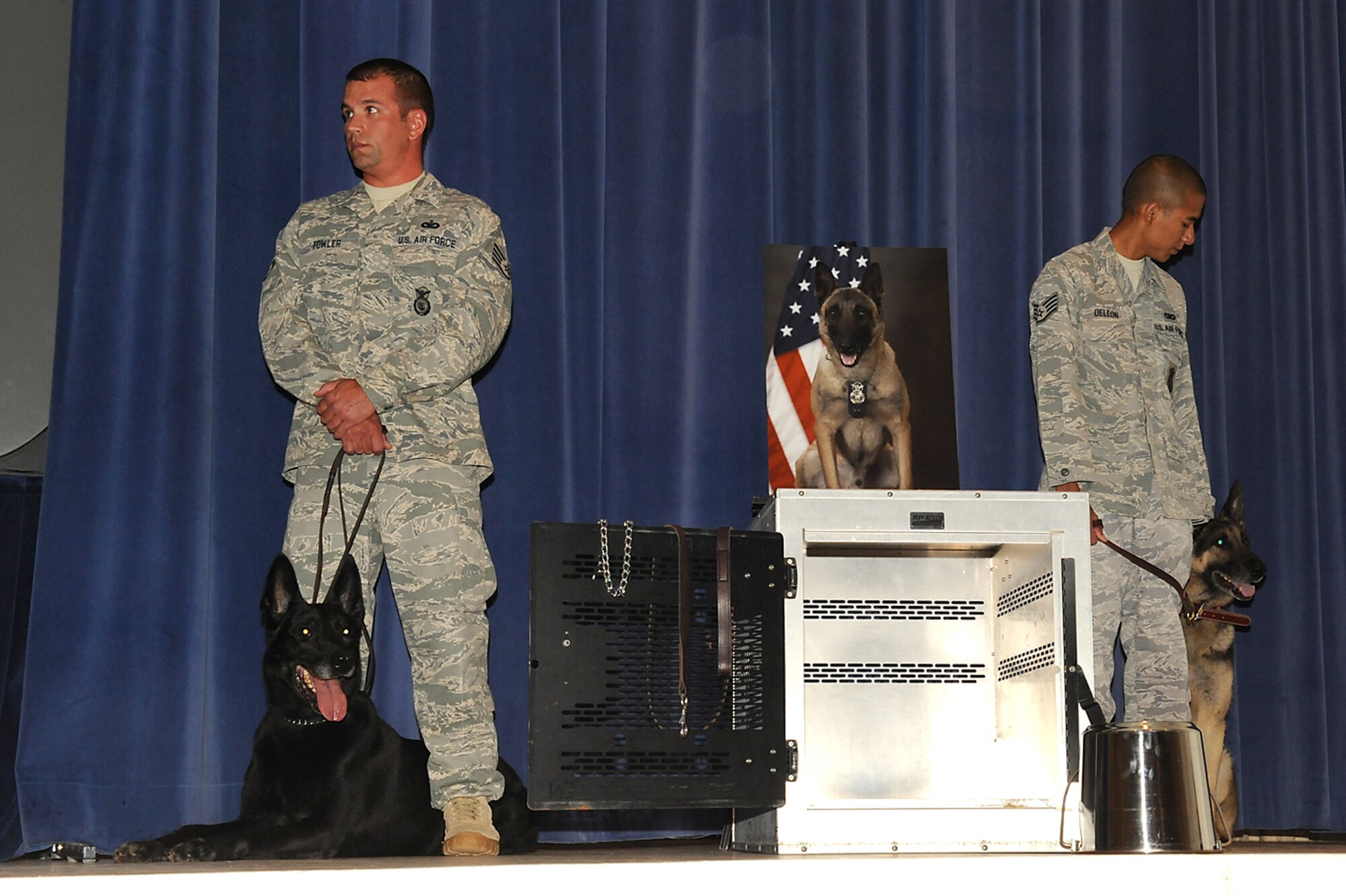 Dog handlers from the 21st Security Forces Squadron at Peterson AFB and their military working dogs stand vigil at Chaky’s kennel, during a memorial service for Chaky June 8. Chaky, an award-winning narcotics detector dog who deployed numerous times, died of cancer three weeks ago. (U.S. Air Force photo/Roberta McDonald)
