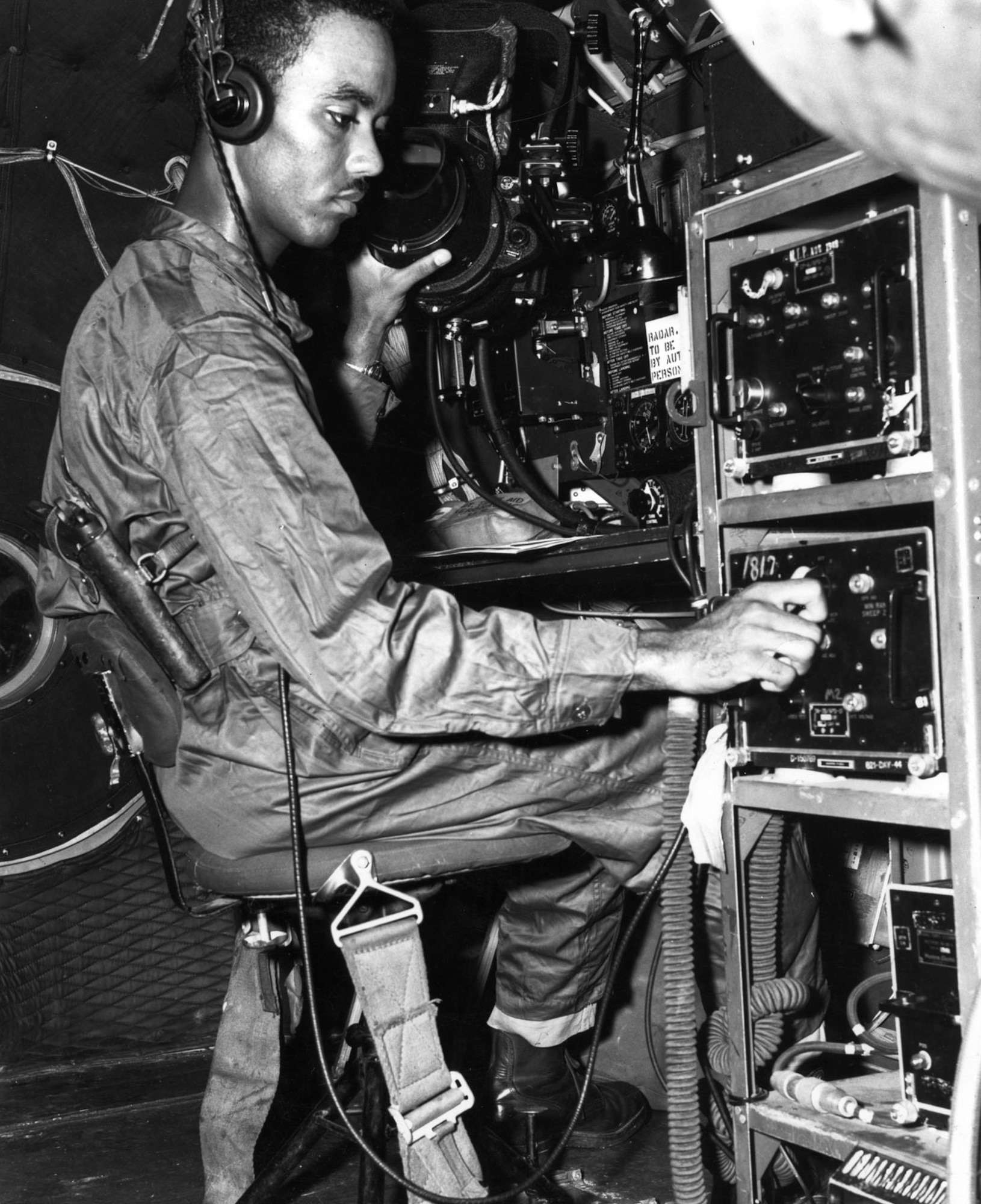 Superfortress radar observer with a pistol strapped to his side in case of bail out over enemy territory. (U.S. Air Force photo)