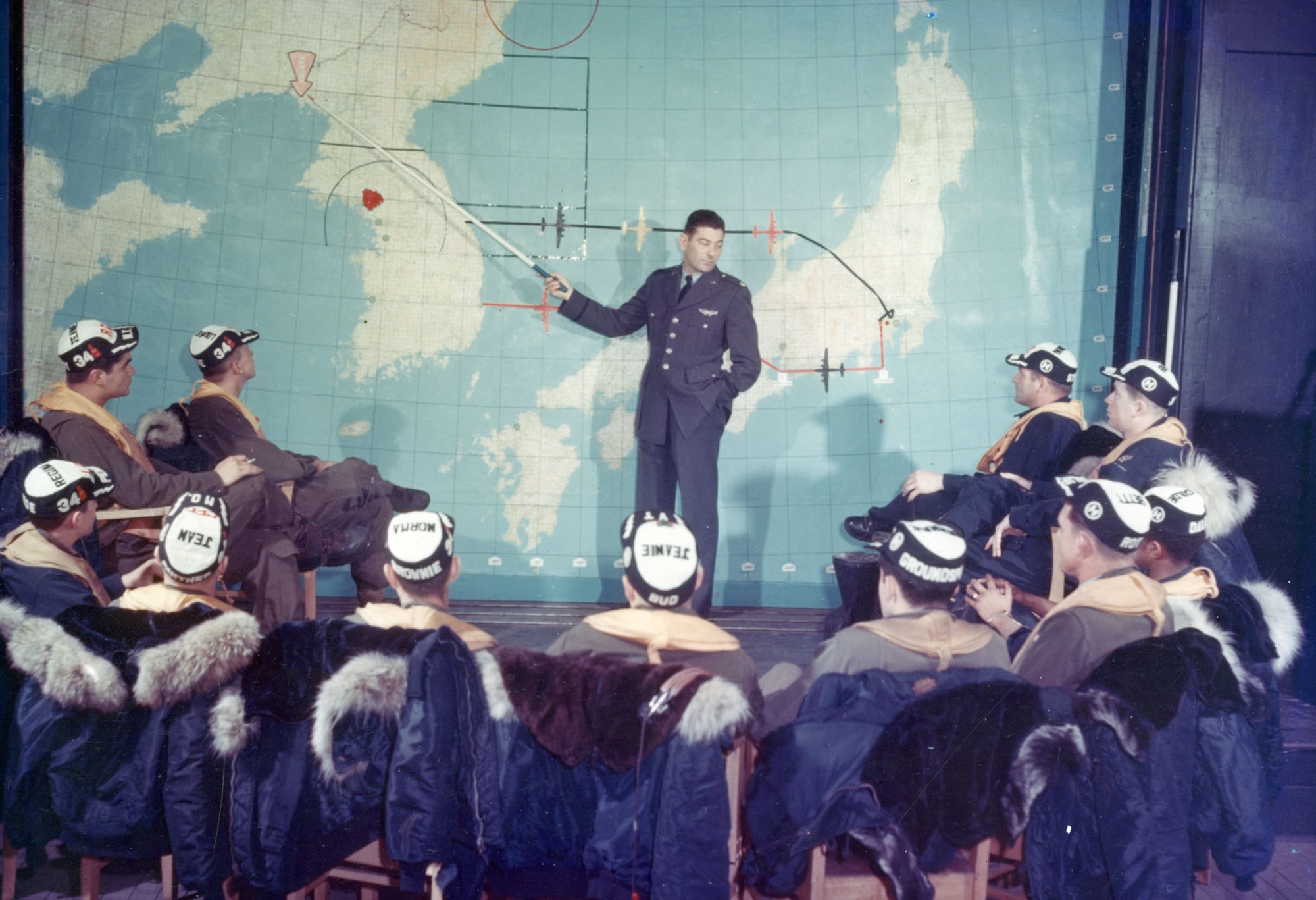 Maj. Harry Bailey points out the often-visited target of Sinuiju, North Korea. On the right of the map is a red dot that represents their starting point, Yokota Air Base near Tokyo, Japan. (U.S. Air Force photo)