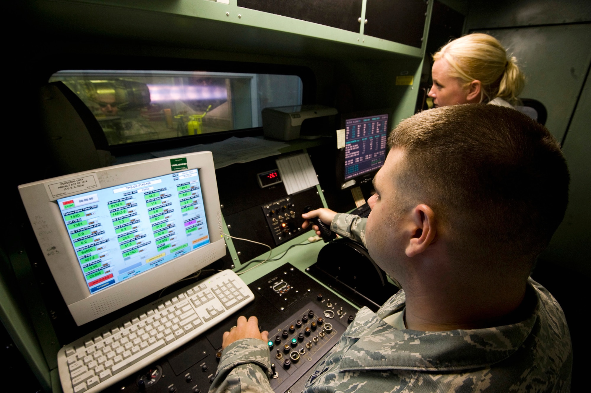 Staff Sgts. Jared Langston and Tracy Madris throttle up an engine from an F-16 Fighting Falcon for a test run in the hush house May 27, 2010, at Misawa Air Base, Japan. The sound-dampening control room protects operators from the 139-decibel roar of the engine. Sergeants Langston and Madris are 35th Maintenance Squadron aerospace propulsion test cell technicians. (U.S. Air Force photo/Staff Sgt. Samuel Morse)