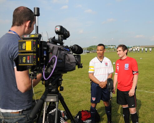 RAF MILDENHALL, England -- Mike Dedousis, USA (white), and Karl Holmes, England, the two team captains, talk live to an international television company before the World Cup kick off match between USA and England at the Hardstand Fitness Center June 11. (U.S. Air Force photo/Judith Wakelam)