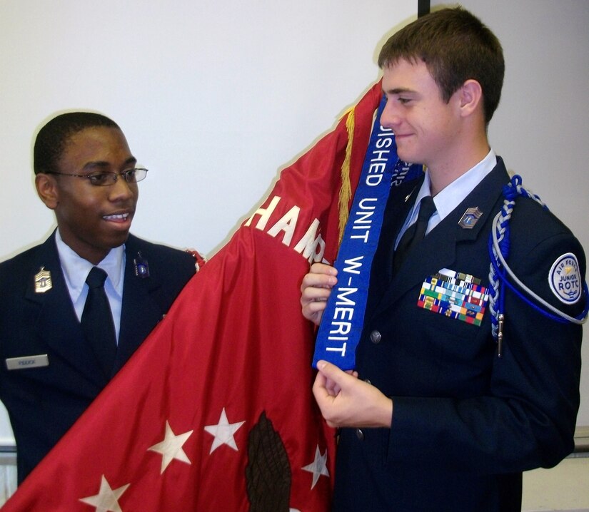 HAMPTON, Va. -- Cadets from Hampton High School's Air Force Junior ROTC unit proudly display the 2009-2010 Distinguished Unit Award with Merit streamer from the unit guidon June 8. The unit received award for outstanding service to the school and surrounding community. (Photo courtesy/Maj. Paul Willard)