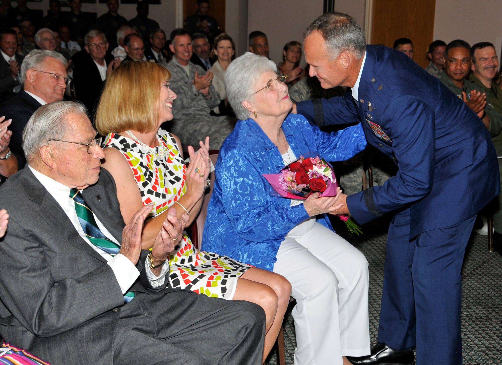 Brigadier Gen. James Browne hands his mother, Marlene Browne, a bouquet of flowers after he received his one-star insignia during his promotion ceremony June 4.  (U.S. Air Force photo/Lisa Norman) 