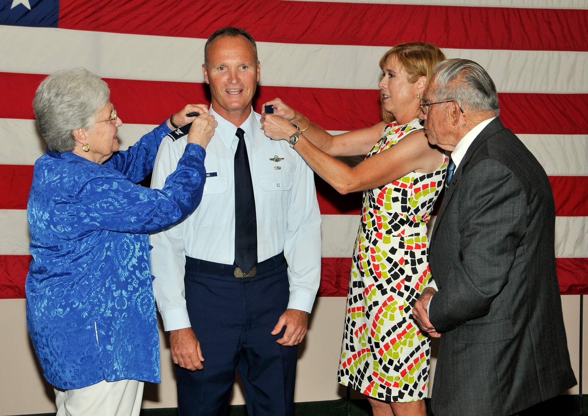 Marlene Browne, mother of 325th Fighter Wing commander, joins Alison Browne, wife of 325th Fighter Wing commander, and her father, John Donnell, pin one-star insignia on newly minted general officer Brig. Gen. James Browne during his promotion ceremony June 4. (U.S. Air Force photo by Lisa Norman)