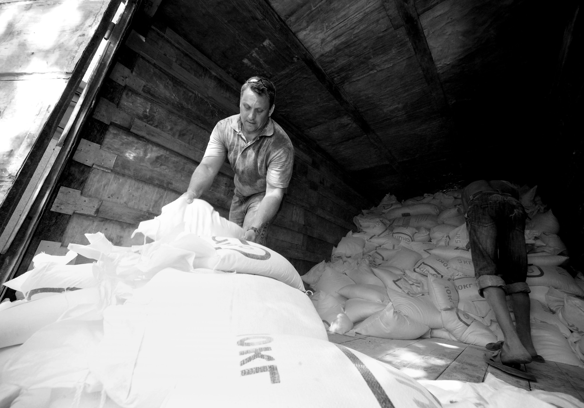 Staff Sgt. Yevgeniy Maksimov, 376th Air Expeditionary Wing coalition coordinator linguist, loads flour onto a delivery truck in Bishkek, Kyrgyzstan, June 13, 2010. The Transit Center, together with the U.S. Department of State, purchased food, fuel, and water totaling more than 31,000 pounds for a humanitarian assistance delivery to the southern region of Osh.  (U.S. Air Force photo/ Senior Airman Nichelle Anderson/ released)