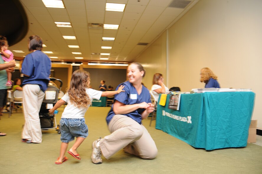 Staff Sgt. Katie Duff a medical tech with the 193rd Special Operations Wing's Medical Group out of Middletown, Pa, plays tag with four-year old Achillez Guiterrez of Hilo, Hawaii, whiles his grandparents are getting a free health screenings. Duff and other members of the 193rd Medical Group provided free health screenings at Prince Kuhio Plaza in Hilo Hawaii on June 11th, 2010. Members of the 193rd Medical Squadron are in Hilo for Medical Innovative Readiness Training.