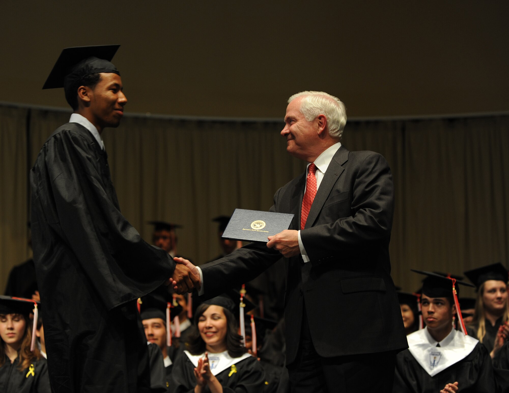 Secretary of Defense Robert M. Gates presents a graduate his diploma at the Kaiserslautern High School graduation ceremony Kaiserslautern, Germany, June 11, 2010.  Secretary Gates accepted the student body's invitation to be the commencement speaker, honoring the many graduates that are also military dependents. (U.S. Air Force photo by Airman 1st Class Caleb Pierce)