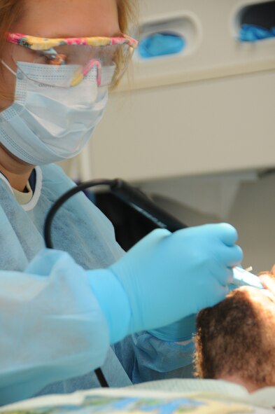 Senior Airman Kim Coolbaugh, cleans the teeth of Ryan Nases, a Hilo Hawaii resident, at Keaau Clinic in Keaau, Hawaii. Coolbaugh is a dental assistant with the 193rd Special Operations Wing's Medical Group out of Middletown, Pa, who are in Hilo Hawaii to preform Medical Innovative Readiness Training.