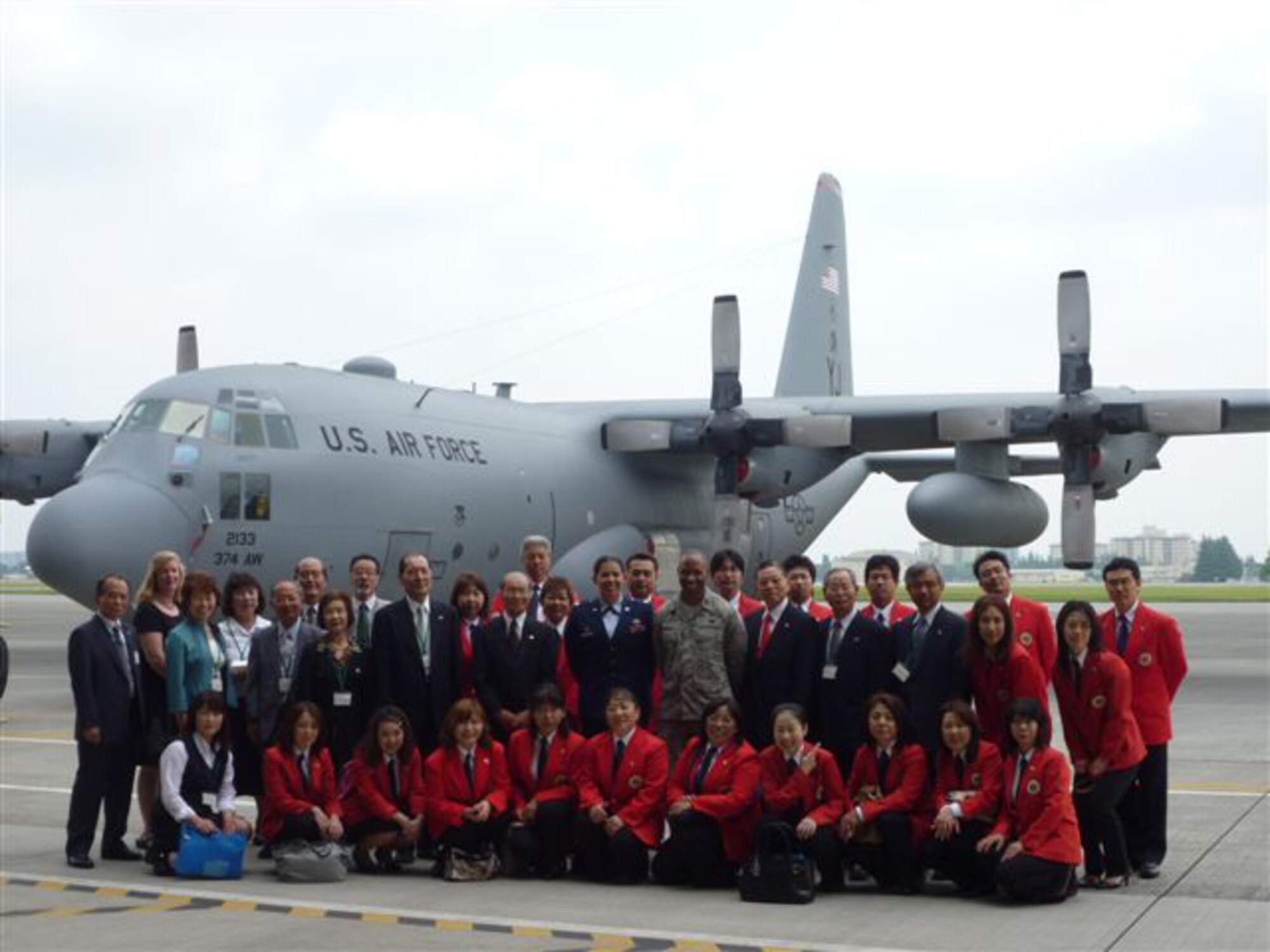 YOKOTA AIR BASE, Japan -- Members from the Mizuho Youth Symphonic Band pose with members of Team Yokota in front of a C-130 airplane at Hangar 15 here June 11. The Mizuho Youth Symphonic Band has been around since 1969 when Hisatoshi Muta, the band conductor, established the band as a way for students to continue practicing music long after they had graduated school. (U.S. Air Force photo/Naoko Kurokui)