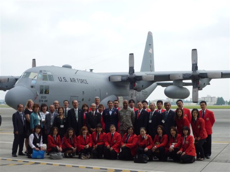 YOKOTA AIR BASE, Japan -- Members from the Mizuho Youth Symphonic Band pose with members of Team Yokota in front of a C-130 airplane at Hangar 15 here June 11. The Mizuho Youth Symphonic Band has been around since 1969 when Hisatoshi Muta, the band conductor, established the band as a way for students to continue practicing music long after they had graduated school. (U.S. Air Force photo/Naoko Kurokui)