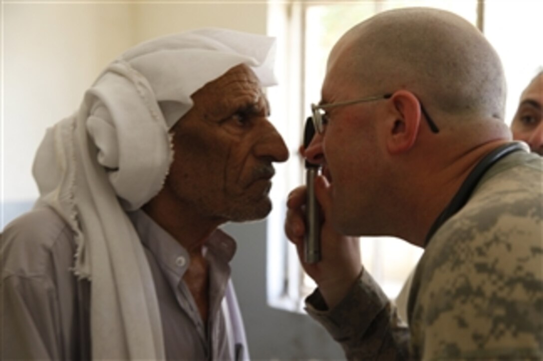 U.S. Army Sgt. 1st Class Ian Francis (right), platoon sergeant for Headquarters and Headquarters Company, 2nd Battalion, 14th Infantry Regiment, 2nd Brigade Combat Team, 10th Mountain Division, examines an elderly Iraqi man in Mullah Fayyad, Iraq, on June 6, 2010.  Francis' unit was in the area participating in a combined medical exercise, in which they set up a temporary medical clinic and pharmacy.  Hundreds of area residents were seen and treated by Army doctors and medics.  