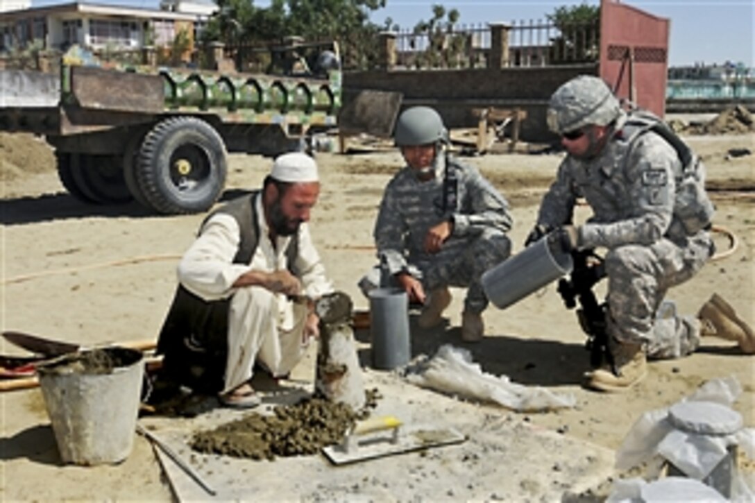 U.S. Navy Petty Officer 1st Class Brian Gamache, right, performs a concrete slump test, which measures moisture in cement, with an Afghan contractor, in Paktika province, Afghanistan, June 12, 2010, Gamache is an engineer for the Paktika Provincial Reconstruction Team, whose members oversee the quality of construction.