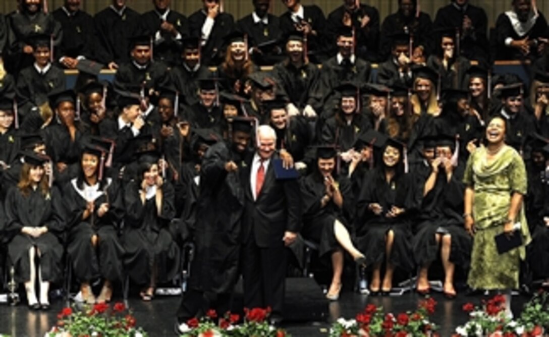 Graduates look on as Secretary of Defense Robert M. Gates receives a hug from a fellow classmate during the Kaiserslautern High School's commencement in the "Fruchthalle" in Kaiserslautern, Germany, on June 11, 2010.  