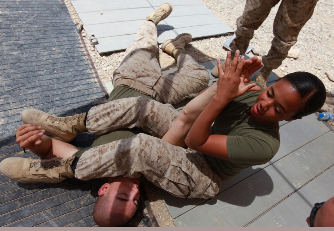 Corporal Jade Myles, 20, from Niagara Falls, N.Y., demonstrates an arm bar maneuver during a Marine Corps Martial Arts Program class at Camp Leatherneck, Afghanistan, June 14. Jade is a radio operator with Headquarters and Service Company, 1st Marine Logistics Group (Forward) and recently reunited with her twin brother, Cpl. Jordan Myles, in Afghanistan after being apart for nearly two years. She also serves as a MCMAP instructor in her spare time.