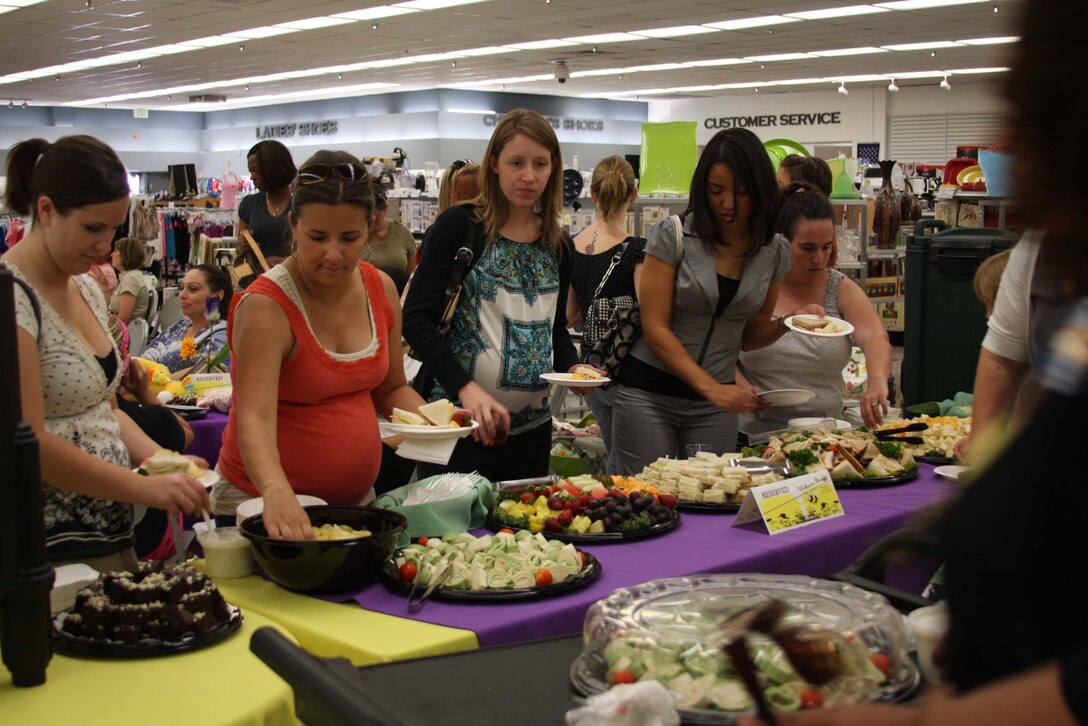 Mothers line up for lunch during the Mothers-to-Bee Social at the Marine Corps Exchange June 15. The social was a service to all mothers to promote programs and services the Combat Center offers new or expectant mothers.::r::::n::