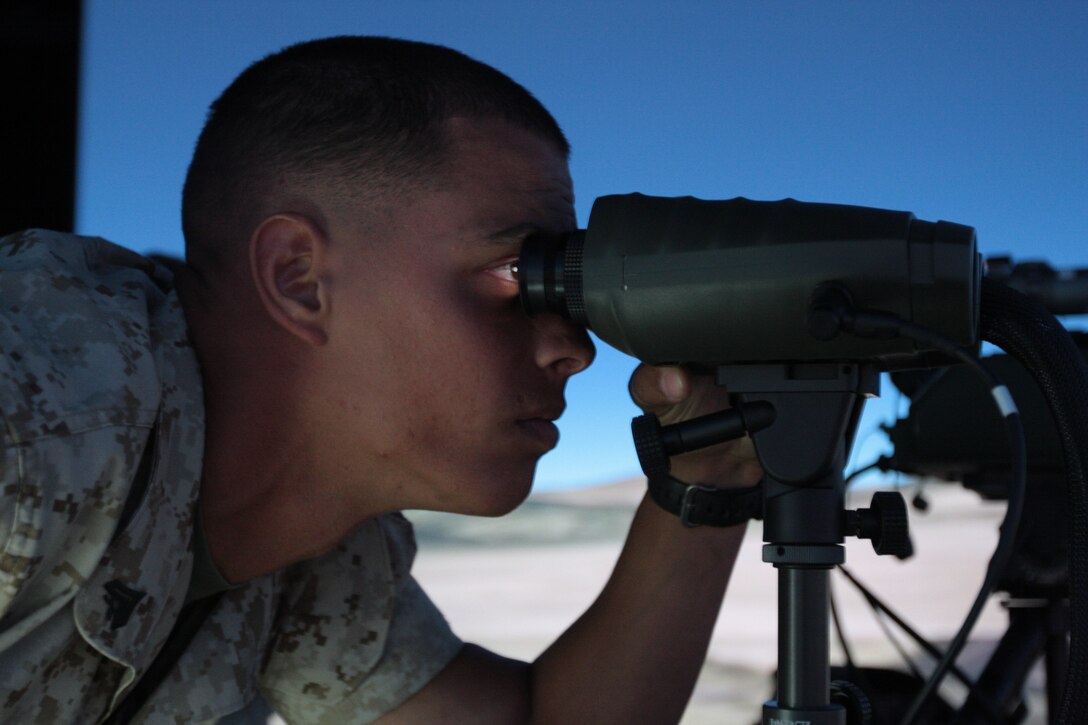 Corporal Omar Curbelo, a light armored vehicle crewman with Company E, 3rd Light Armored Reconnaissance Battalion, looks through the Vector 21B binoculars to find the simulated targets at the Supporting Arms Virtual Trainer June 15. The trainer gives Marines a chance to call in mortar, artillery and air strikes against simulated enemy positions.