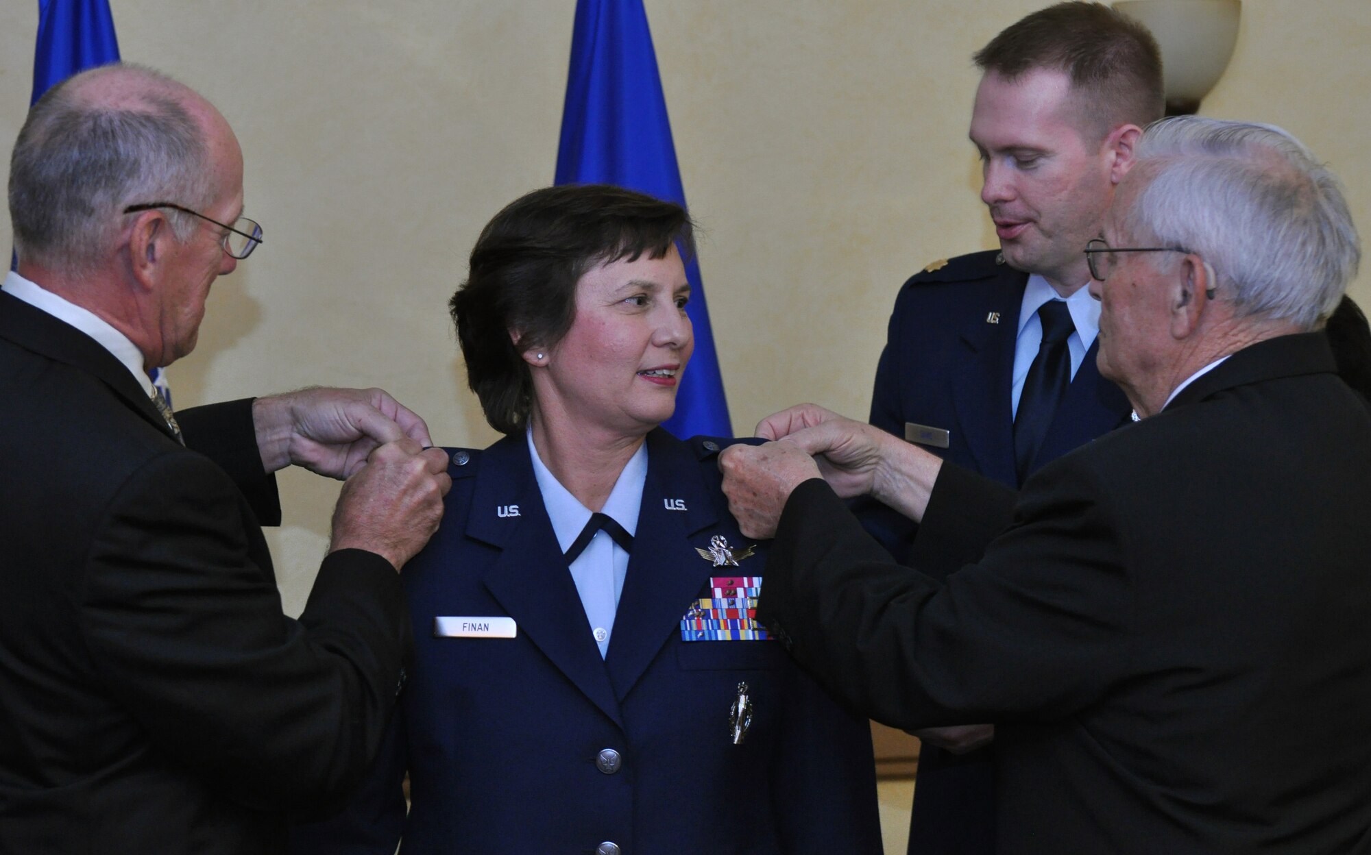 BARKSDALE AIR FORCE BASE, La. –Col. (ret) Chuck Finan (left), husband of Air Force Global Strike Command Inspector General Brig. Gen. Sandra Finan, and her father, Mr. Delmar Chase, pin handmade brigadier general’s stars on the general at her promotion ceremony June 15 at the Barksdale Club.  (U.S. Air Force photo/Master Sgt. Corey Clements)